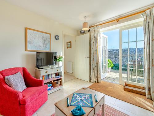 a living room with a red chair and a tv at Hop Cottage - Ukc6134 in Eastdean