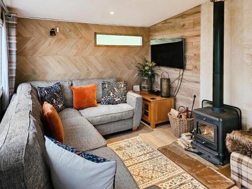 a living room with a couch and a stove at Rowan Tree Lodge - Ukc6977 in Ludlow
