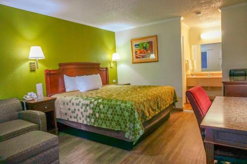 a hotel room with a bed and a couch at Rodeway Inn & Suites Fort Jackson in Columbia