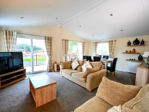 a living room with a couch and a tv at Serenity Lodge-Uk3456 in Felton