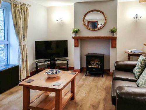 a living room with a television and a fireplace at Milking Parlour - Uk4017 in Hartington
