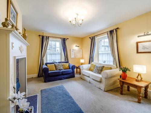 a living room with two couches and a fireplace at Peaseblossom House in Alnwick