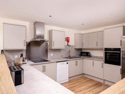 a white kitchen with white cabinets and appliances at Lundin Lodge - Ukc5802 in Lundin Links