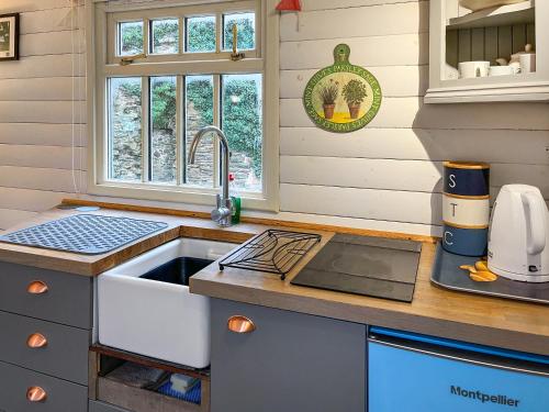 a kitchen with a sink in a tiny house at The Shepherds Hut - Uk50986 in Sheriff Hutton
