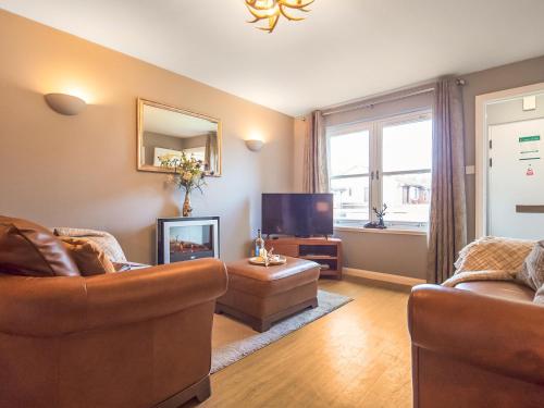 a living room with two couches and a flat screen tv at Dalmore-Ukc5067 in Aviemore