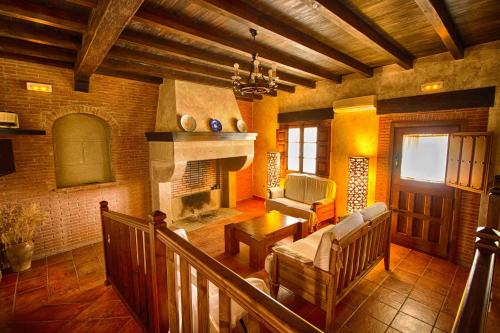 Casa Rural Tia Tomasa في مالبارتيدا دي بلاسينثيا: غرفة معيشة مع أريكة ومدفأة