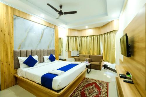 a bedroom with a large bed and a couch at Hotel Sapphire International in Puri