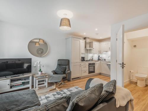 a living room with a couch and a kitchen at Lilypad in Ringwood