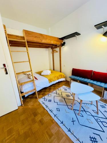 a bedroom with a bunk bed and a couch at L'escale Annécienne in Annecy