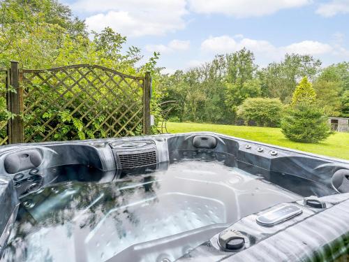 a jacuzzi tub in a backyard with a fence at Jasmine Cottage - Uk35245 in Llanfyrnach