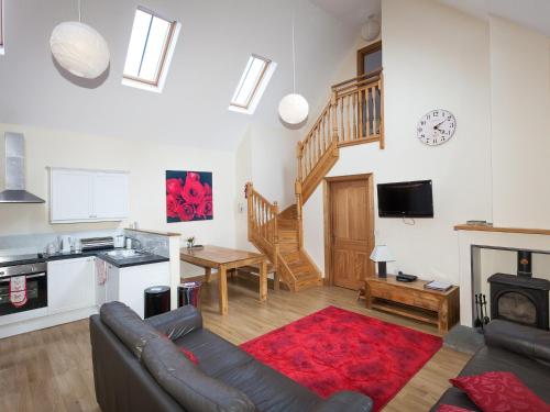 a living room with a couch and a kitchen at Honeysuckle Cottage - Ukc6255 in Linlithgow