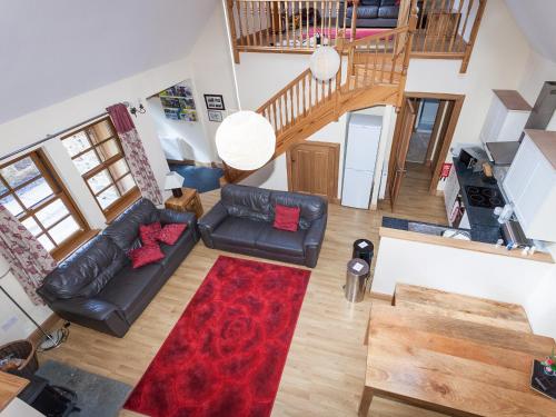 a living room with a couch and a red rug at Honeysuckle Cottage - Ukc6255 in Linlithgow