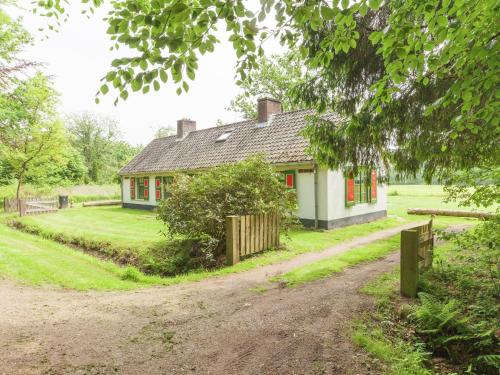 una casa blanca con ventanas rojas y un camino de tierra en Cozy Holiday Home near Forest in Baarn, en Baarn