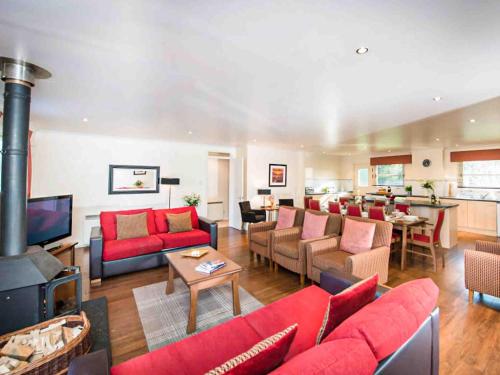 a living room with red furniture and a fireplace at Golden Eagle-Ukc5057 in Aviemore