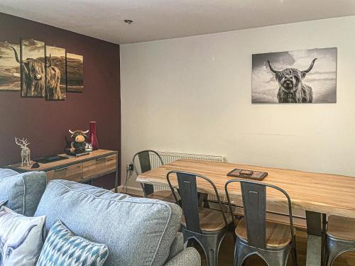 a living room with a table and a cow on the wall at Raven Wing 17 - Ukc4882 in Fort Augustus