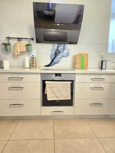 a kitchen with a stove and a tv on the wall at Your home in Pardes Hanna in Pardes H̱anna