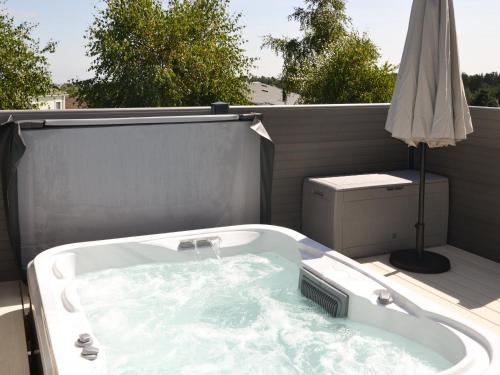 a bath tub on a balcony with an umbrella at Herdwick Lodge - Uk3426 in Newton on the Moor