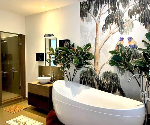 a bathroom with a bath tub and some plants at Penthouse - Sea view, Private roof top pool, Golf in Roches Noires