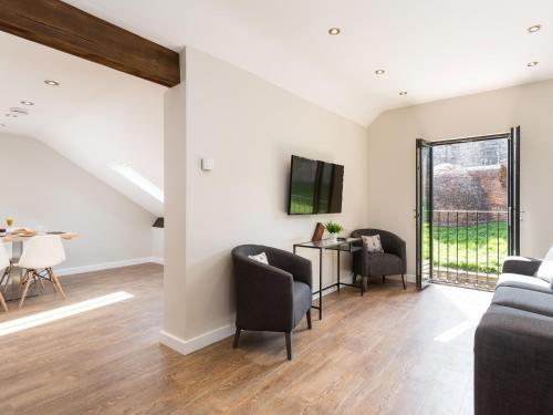 a living room with a couch and chairs and a tv at 1 Monkbar Mews - Uk2690 in York