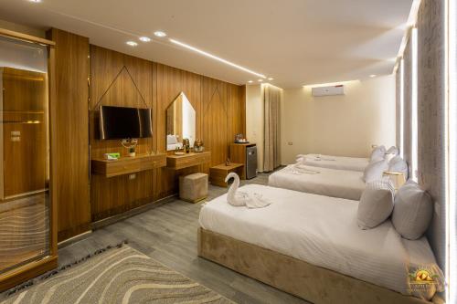 a hotel room with two beds and a television at Khofo pyramids view inn in Cairo