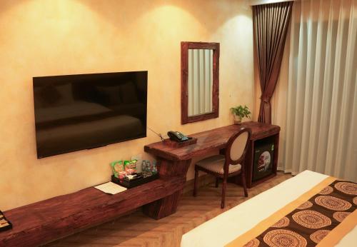 a bedroom with a desk and a television in a room at SENVIBE Resort in Vằn Trinh
