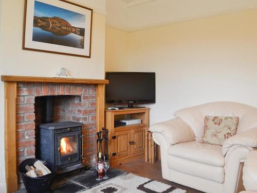 a living room with a fireplace and a tv at Bevan House in Llansaintfraed in Elvel