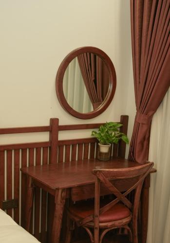a wooden table with a potted plant and a mirror at SENVIBE Resort in Vằn Trinh