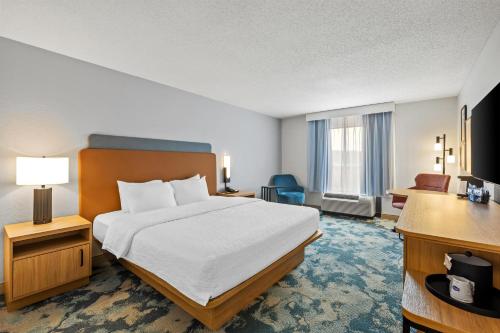 a hotel room with a bed and a desk at Hampton Inn Carrollton in Carrollton