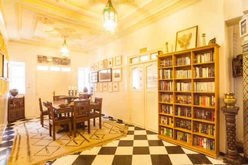 a library with a table and book shelves with books at Riad Dar Sofian in Zagora