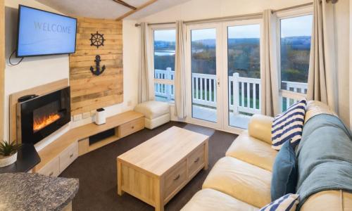 a living room with a couch and a tv at Riverscape Northumberland in Ashington