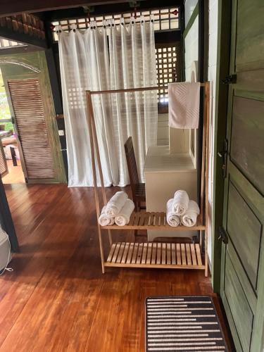 a room with a shower with towels on a wooden floor at Mi Casa - The gem of Ijen in Banyuwangi