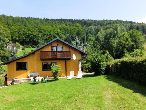 ein Haus mit einer Terrasse und Stühlen im Hof in der Unterkunft Holiday home near the ski area in Kurort Steinbach-Hallenberg