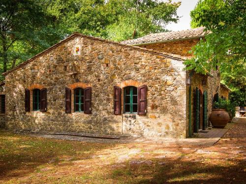 un antiguo edificio de piedra con ventanas en un patio en Belvilla by OYO Holiday Home with Pool, en Canneto