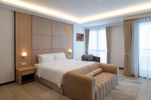 a hotel room with a bed and a couch at Asteria Melaka by Attic Suite in Malacca