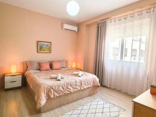 a bedroom with a bed and a large window at Shkodra Apartments in Shkodër