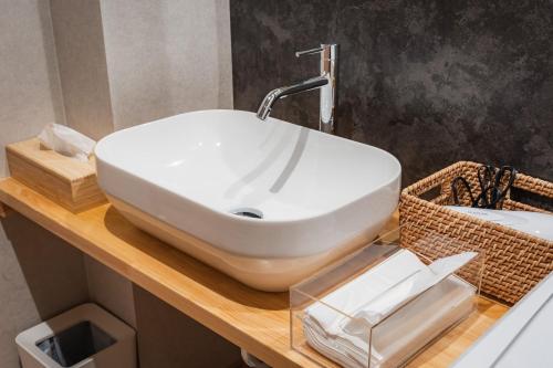 a bathroom with a white sink on a wooden counter at 月詠 Tsukuyomi in Fujikawaguchiko