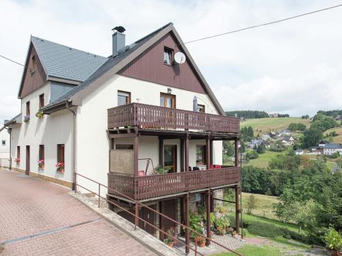 a house with a balcony on a brick road at Cozy Apartment in Ore Mountains with Balcony in Breitenbrunn