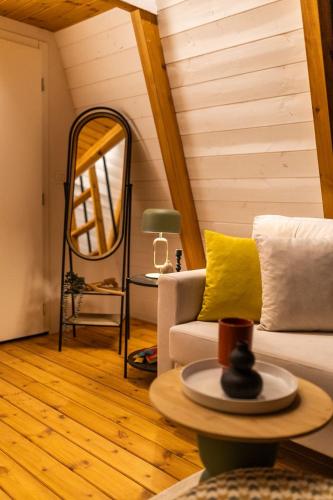 a living room with a couch and a mirror at Funky Cabins Villas and Chalets - Gaia Park in Tirana