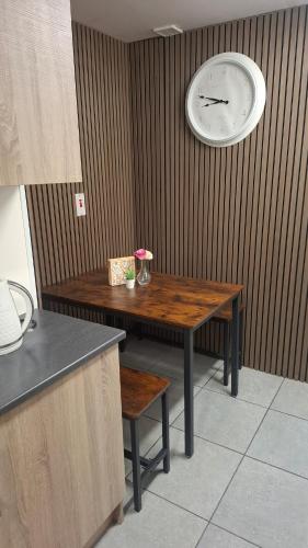 a table with a clock on the wall and a table with a chair at Apartment 1 at Busy Bee in Daingean