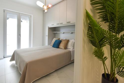 a bedroom with a bed and a potted plant at LifeStyle Boutique Apartment in Monopoli