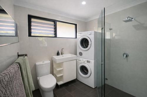 a bathroom with a toilet sink and a washing machine at Coastal Stay in Cronulla