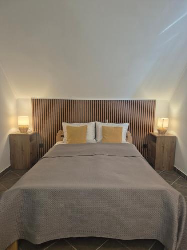a bedroom with a large bed with two lamps at Wine House Kaloh in Maribor