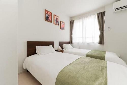 a hotel room with two beds and a window at Tsukimi Inn Shinkoiwa in Tokyo