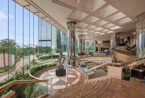 a lobby with a staircase and large windows at JW Marriott Hotel Hong Kong in Hong Kong