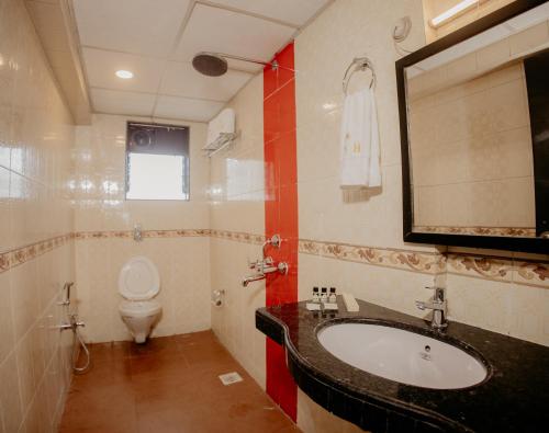 a bathroom with a sink and a toilet at Om Shiv Hotel Formerly The Treat Hotel in Madgaon