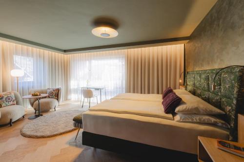 a bedroom with a large bed and a living room at nōa Schladming in Schladming