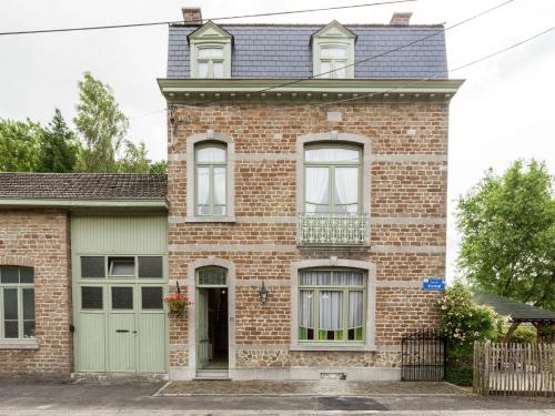Comblain-au-PontにあるAuthentic village house with romantic garden and wooden gazeboの緑のガレージのある古いレンガ造りの家