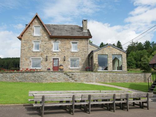 een huis met twee banken ervoor bij Spacious and well cared for house with a panoramic view sauna and a summer pool in Habiemont