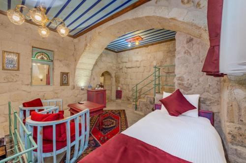 a bedroom with a bed and chairs in a room at Han Cave Suites - The Special Class in Göreme