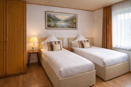 a hotel room with two beds and a window at SK Ferienapartments Kappelrodeck in Kappelrodeck